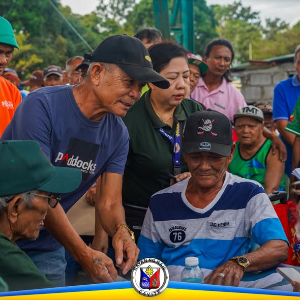 Mga senior citizen na tumatanggap ng tulong habang may kawani ng programa sa Brgy. Halang, Naic