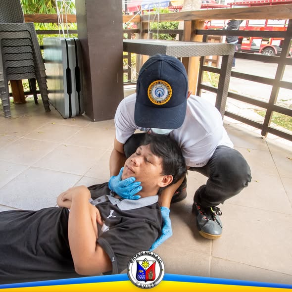 Pagsasanay sa Basic Life Support: rescuer na nagsasagawa ng first aid sa taong nakahiga sa covered area