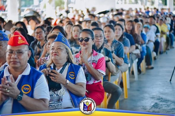 Mga dumalo sa SOMA 2026 na nakaupo sa ilalim ng covered area sa Naic Town Plaza, nakikinig sa programa