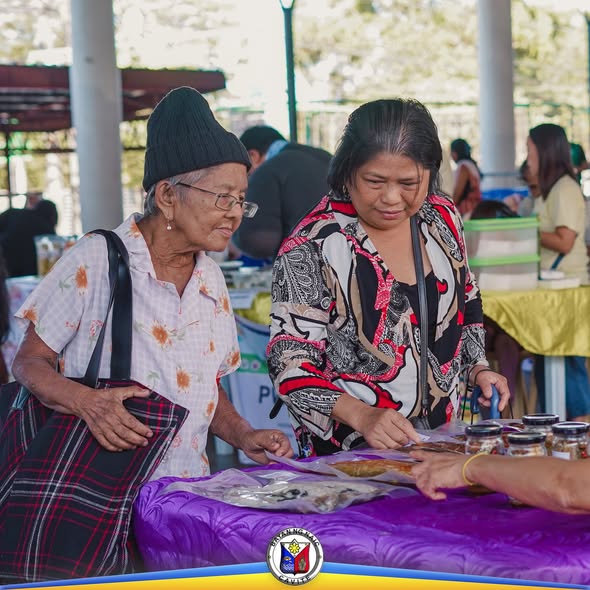Mga mamimili na tumitingin sa mga produkto sa Kadiwa ng Pangulo sa Naic Town Plaza