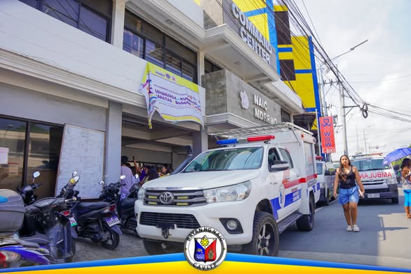 Rescue vehicle sa harap ng Naic Command Center, may banner ng MDRRMO Open House sa entrance