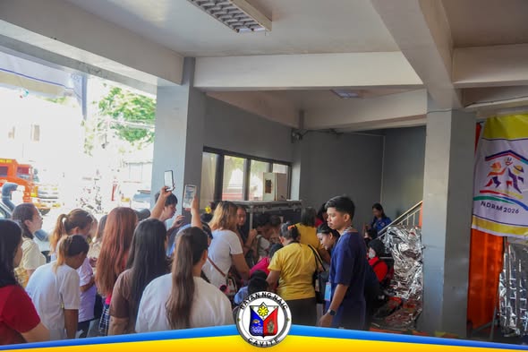 Mga tao at bata na nanonood at kumukuha ng litrato sa open house ng MDRRMO sa Naic Command Center