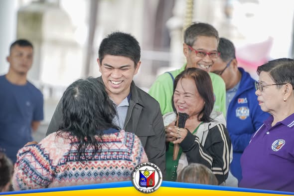 Mga residente at kawani habang nagproseso ng National Social Pension validation sa Naic Town Plaza