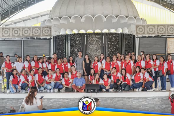 Grupo ng mga bata at guro na nakapose sa harap ng gazebo sa Naic Town Plaza para sa Nutrition Month