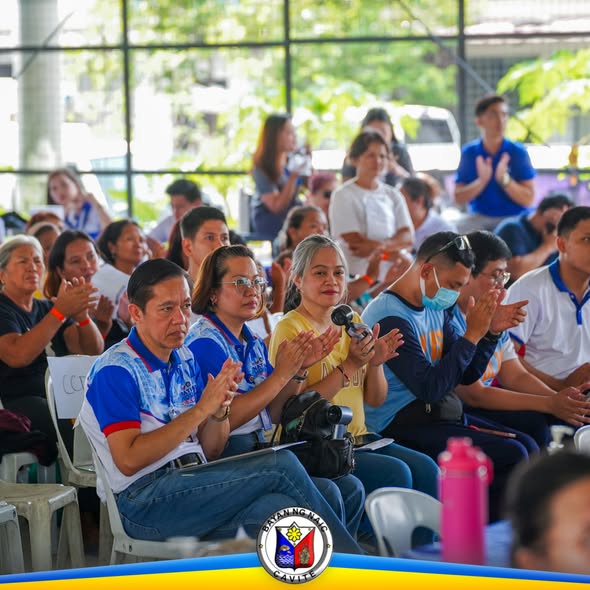Mga dumalo sa NHA People's Caravan sa Rancho Verde 2 na nagpapalakpakan habang nakaupo sa covered court