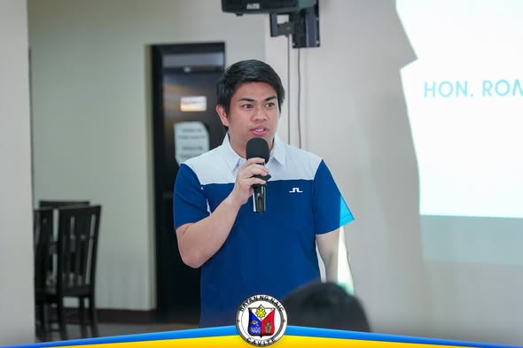 Isang tagapagsalita na may hawak na mikropono habang nagsasalita sa loob ng hall sa ABC Hall, Naic
