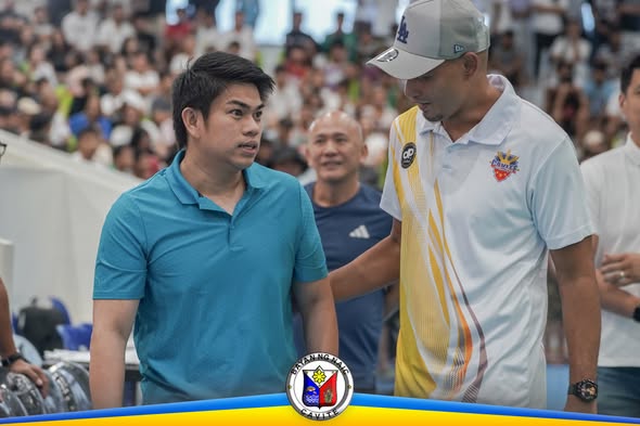 Mga opisyal na nag-uusap sa gilid ng court habang nanonood ang mga tao sa Cavite Ballers League finals