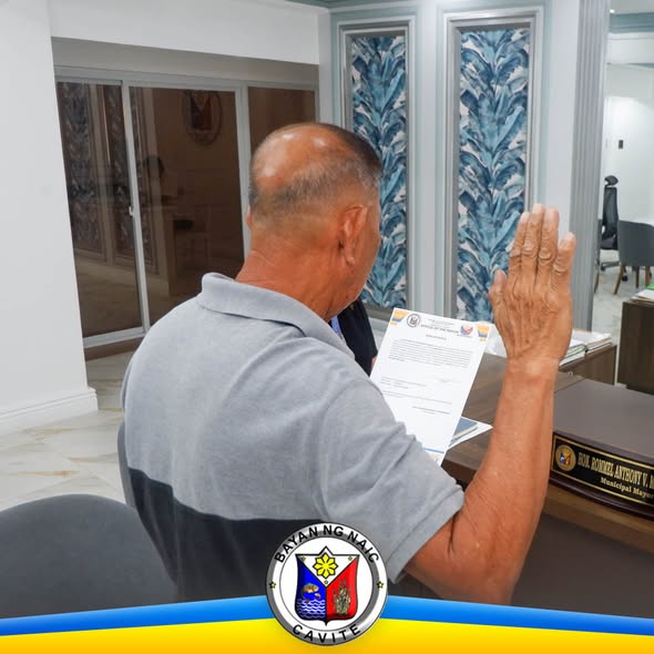 Litrato: lalaki na nagtataas ng kanang kamay habang nanunumpa sa Naic Municipal Hall