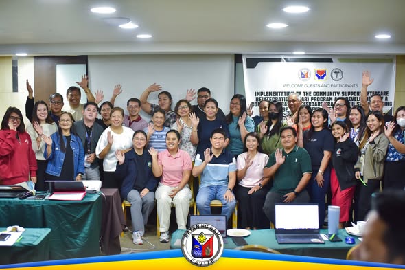 Grupo ng mga kalahok na nakataas ang kamay sa seminar ng CSAR Program sa Tanza Oasis Hotel, Naic