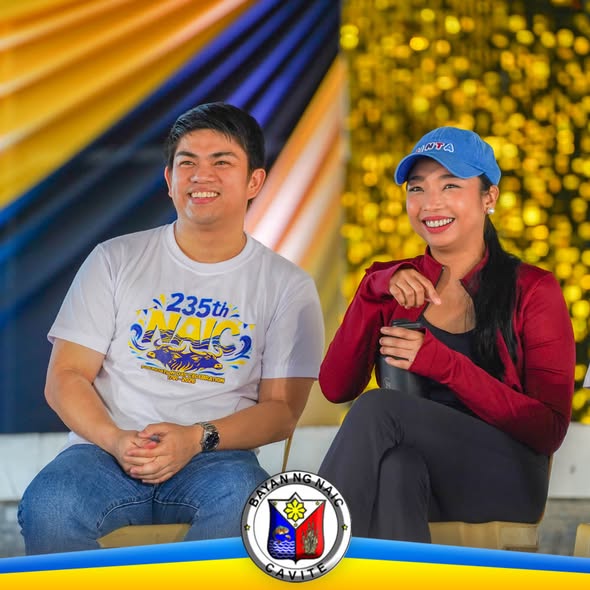 Dalawang tao na nakangiti habang nakaupo sa entablado ng 235th Founding Anniversary ng Naic