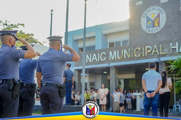 Mga pulis na nagsaludo habang nagaganap ang flag raising ceremony sa harap ng Naic Municipal Hall