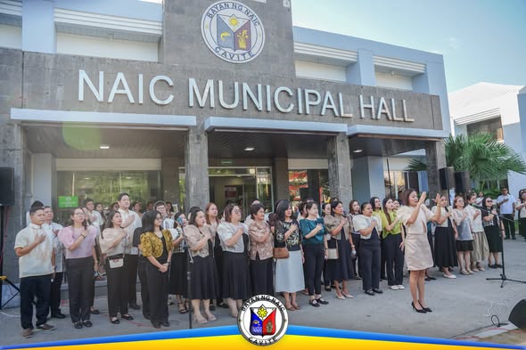 Mga kawani ng Naic habang nagpupugay sa watawat sa harap ng Naic Municipal Hall