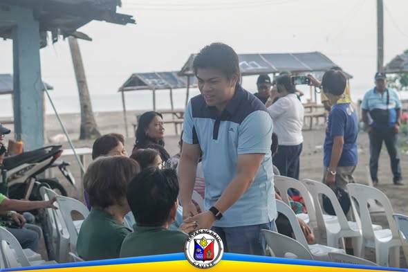 Isang opisyal na nakikipagkamay sa mga senior citizen sa Elderly Filipino Week 2026 Kick-Off sa Timalan Concepcion, Naic