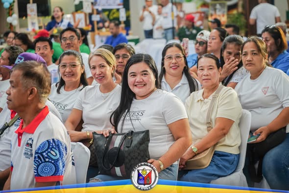 Mga miyembro ng kooperatiba na nakaupo at nakangiti habang dumadalo sa Municipal Coop Month kick-off sa Naic