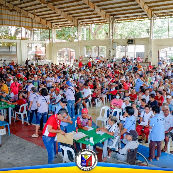 Malaking pulutong ng mga nakatatanda sa covered court habang inaasikaso sa mga mesa ng pagbabayad ng social pension