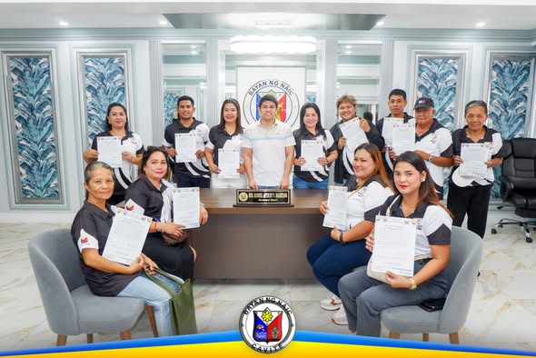 Mga bagong opisyal ng homeowners association na may hawak na dokumento matapos ang panunumpa sa opisina ng Naic