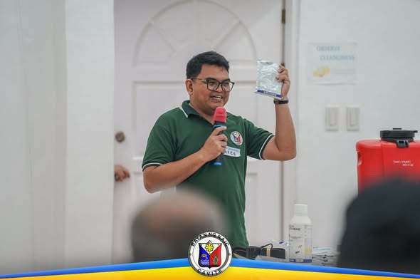 Tagapagsalita habang ipinapakita ang maliit na plastik sa Dengue Awareness Seminar sa Amisa Medical Mission, Naic
