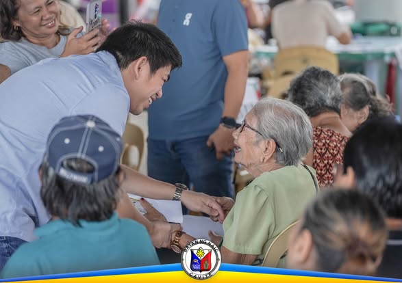 Mga senior citizen na tumatanggap ng social pension sa Naic Town Plaza habang inaasikaso ng kawani