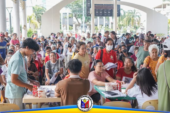 Mga senior citizen na nakapila at tumatanggap ng ayuda sa covered court ng Naic Town Plaza