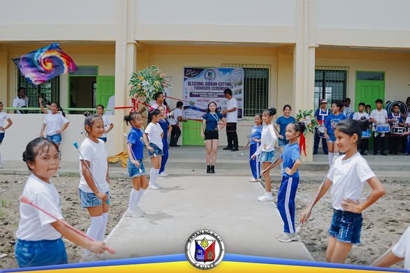 Mga batang estudyante na nagpapakita sa harap ng bagong school building sa Timalan Hills View Integrated School