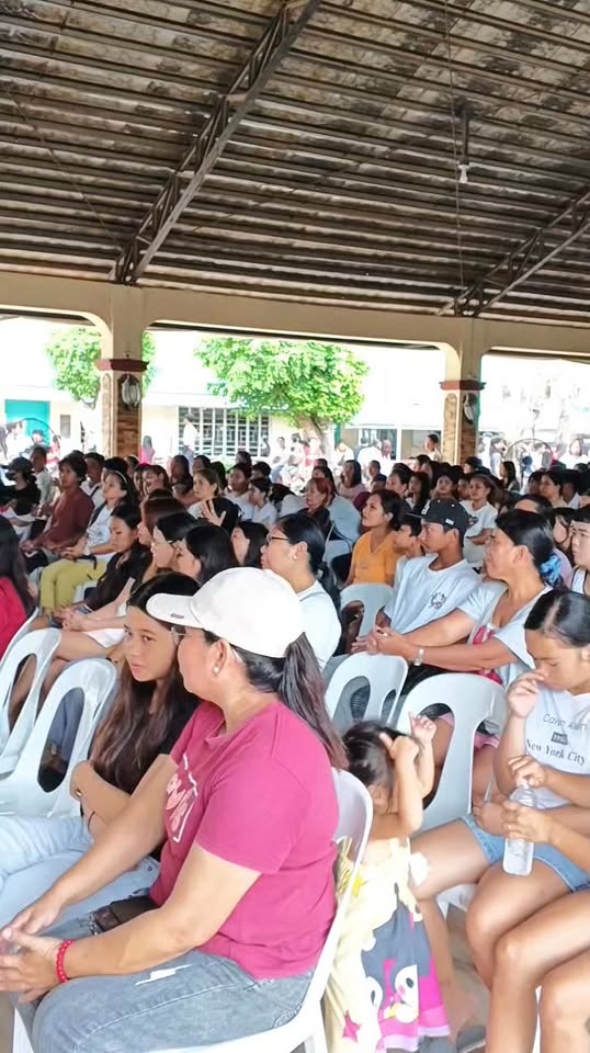 Mga dumalo sa orientation ng Naic Integrated National Highschool na nakaupo sa covered court habang nakikinig