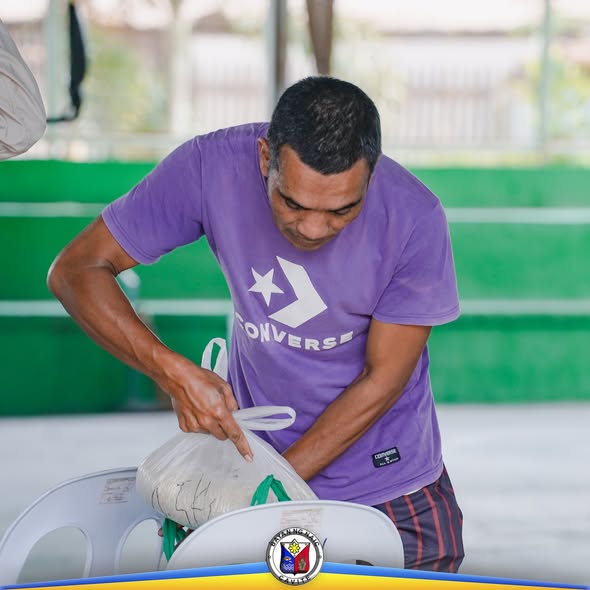 Lalaki habang inaayos ang sako ng bigas sa KADIWA Rice Selling sa Labac Covered Court