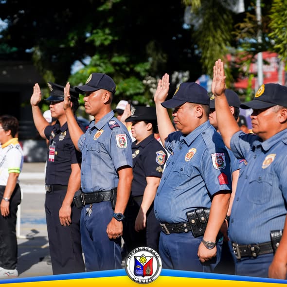 Mga uniformadong kawani na nagsaludo habang flag raising ceremony sa Naic Municipal Hall