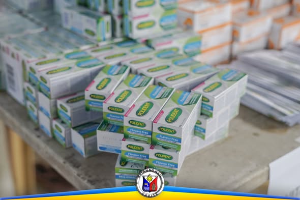 Mga nakasalansang kahon ng Polident na may markang Flavor Free sa ibabaw ng mesa sa Naic