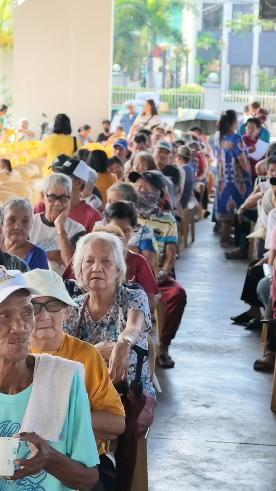 Mga senior citizen na nakaupo at naghihintay sa covered area ng Naic Town Plaza para sa pension program