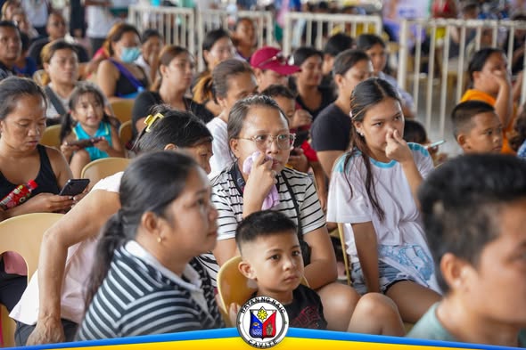 Mga manonood na nakaupo sa World Rabies Day 2026 sa Naic Town Plaza, nakikinig sa programa