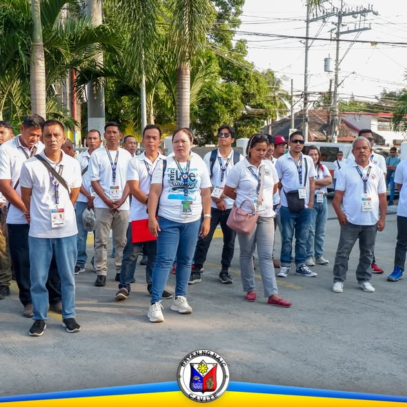 Mga kalahok na nakaputing polo at lanyard habang nakatayo sa kalsada sa Naic Municipal Hall, Flag Raising Ceremony