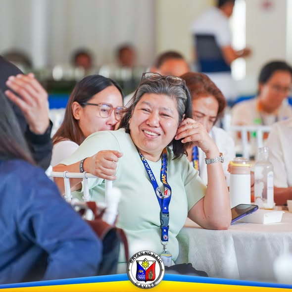 Mga kalahok sa Revenue Code Seminar na nakaupo at nakangiti sa mesa sa loob ng bulwagan sa Naic