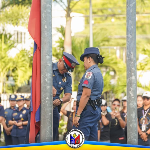 Mga pulis na nagpapababa ng watawat sa flag raising ceremony sa Naic Municipal Hall, Pebrero 23, 2026