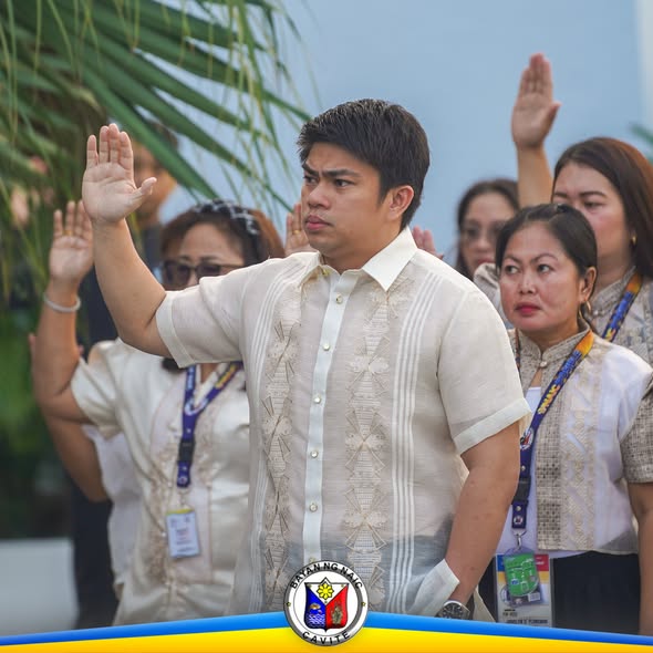 Mga kawani na nakataas ang kamay sa flag raising ceremony sa Naic Municipal Hall