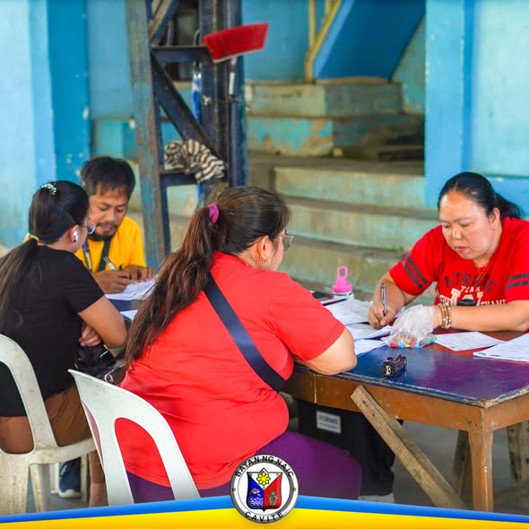Mga kawani na nagpoproseso ng papeles para sa Fisherfolk Registration sa covered court ng Bucana Sasahan