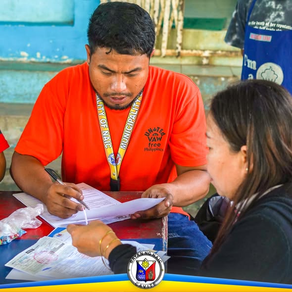 Pag-aasikaso ng fisherfolk registration, may staff ng munisipyo na nagsusulat ng form sa mesa