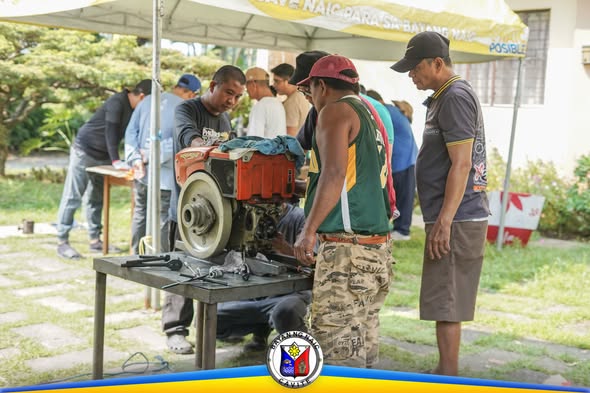 Mga kalahok na nagsasanay sa pagkukumpuni ng single cylinder engine sa labas ng King Solomon Function Hall, Malainen Bago