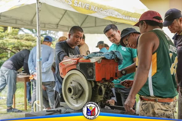 Mga kalahok na nagsasanay sa pagkukumpuni ng single cylinder engine sa ilalim ng tent sa Malainen Bago, Naic