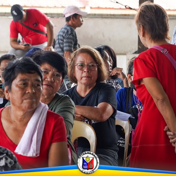 Mga benepisyaryo na naghihintay habang nakaupo sa covered area sa Verdant Homes, Sabang