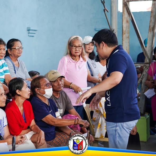 Mga residente sa Verdant Homes, Sabang, habang tumatanggap ng dokumento mula sa isang opisyal sa pamamahagi ng pensyon