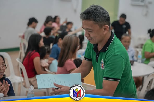 Pagsasanay sa vegetable production sa Amisa Medical Mission, Naic; lalaking nagbabasa ng papel habang nakikinig ang mga…