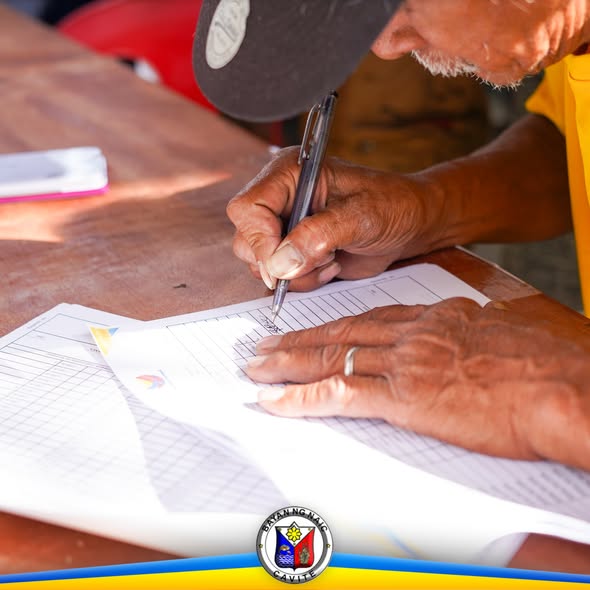 Matandang nagsusulat sa papel na form para sa Localized Pension Plan sa Ciudad Nuevo Phase 1, Naic