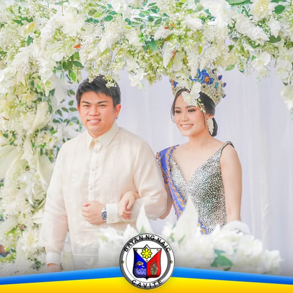 Litrato ng dalawang kalahok na nakangiti sa ilalim ng arko ng puting bulaklak sa Sunduan Festival 2026, Naic
