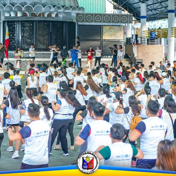 Mga kalahok na naka-puting t-shirt habang nagza-zumba sa Naic Town Plaza para sa Pawikan Zumba program
