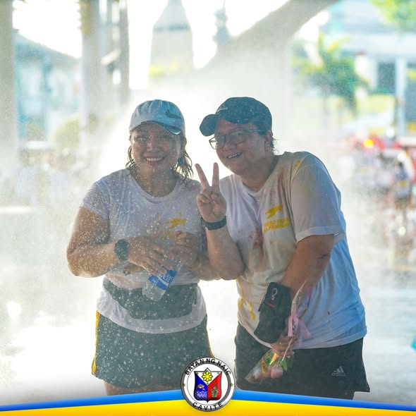 Dalawang kalahok na nagpapakuha ng litrato habang nababasa ng tubig sa Pawikan Zumba sa Naic Town Plaza