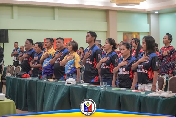 Mga kalahok ng seminar na nakatayo at nakahawak sa dibdib habang umaawit ng pambansang awit sa function room