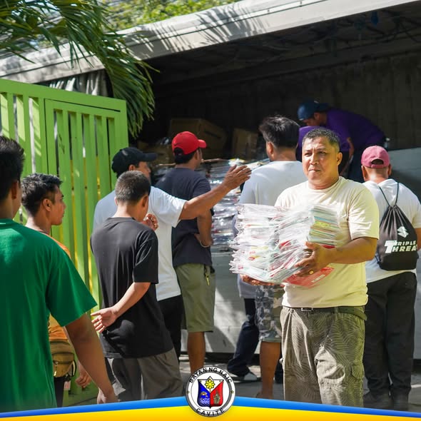 Mga tao habang nagbubuhat ng school supplies mula sa truck para sa mga paaralan sa Naic