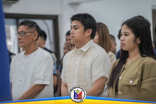 Mga taong nakatayo sa seremonya ng Flag Raising sa Naic Municipal Hall habang nagbibigay-galang