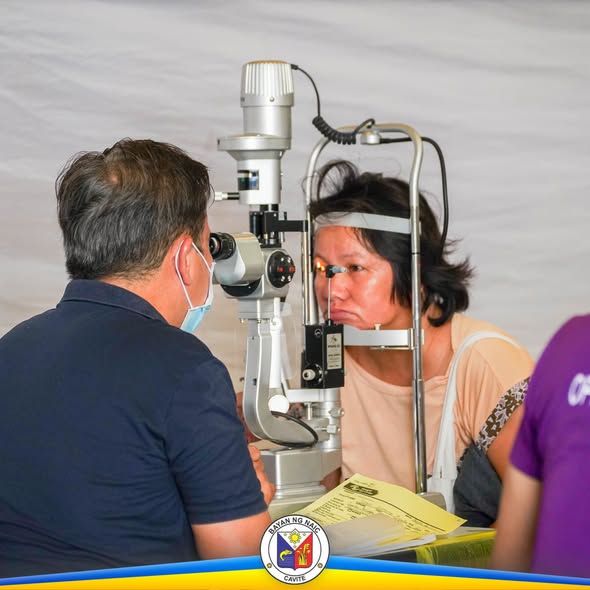 Eye check-up sa medical mission: isang doktor na sinusuri ang mata ng pasyente gamit ang slit lamp sa loob ng tent