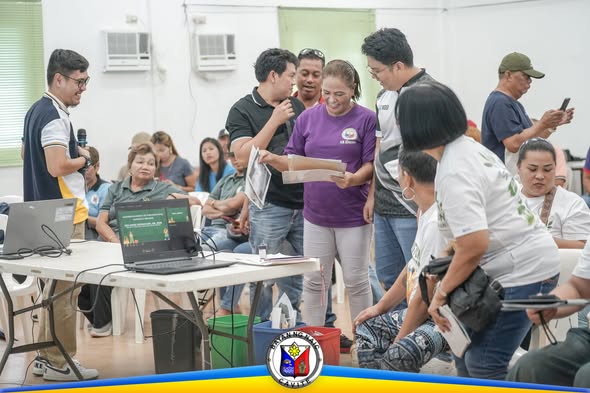 Mga kalahok sa Nutrisyon at Kalikasan training habang tumitingin ng mga papel sa loob ng hall sa Amisa Medical Mission